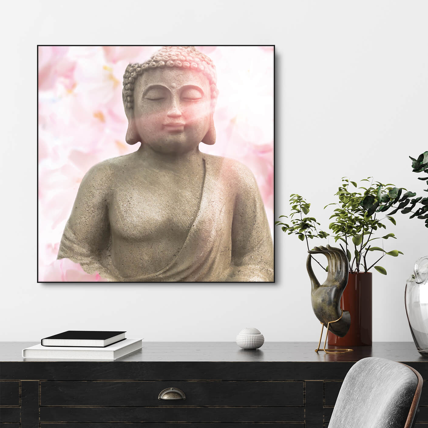 Stilvolle Kommode mit Tysta Akustikbild Asien Buddha mit Buddhastatue und rosa Kirschblüten. Schwarzer Bilderrahmen im Quadrat.