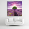 Schallschutzbild Dreamy mit Lavendelfeld, lila farbenen Himmel und Baum. Schwarzer Rahmen im Quadrat über weißem Sofa.