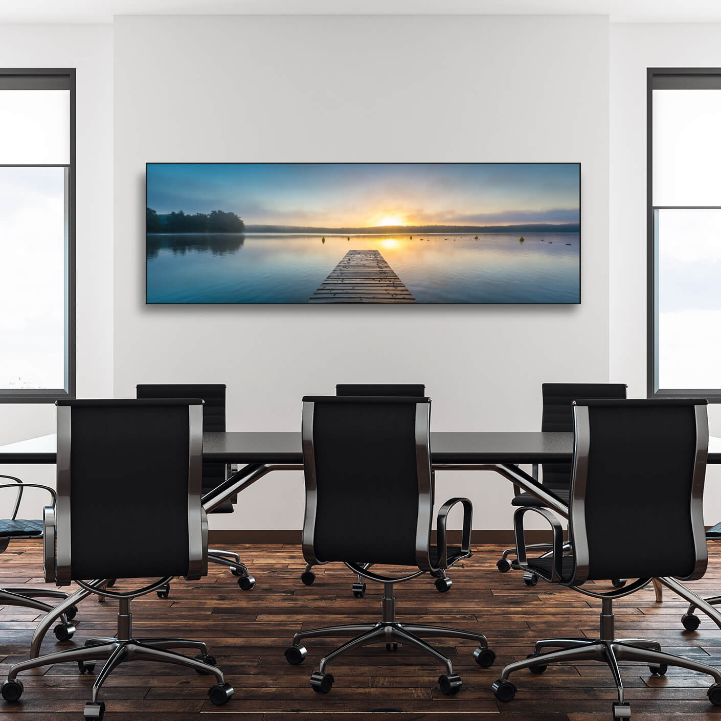 Konferenzraum mit langem Tisch, Bürostühlen und Schallschutzbild mit Bootssteg im See bei Sonnenaufgang. Schwarzer Rahmen im Querformat.