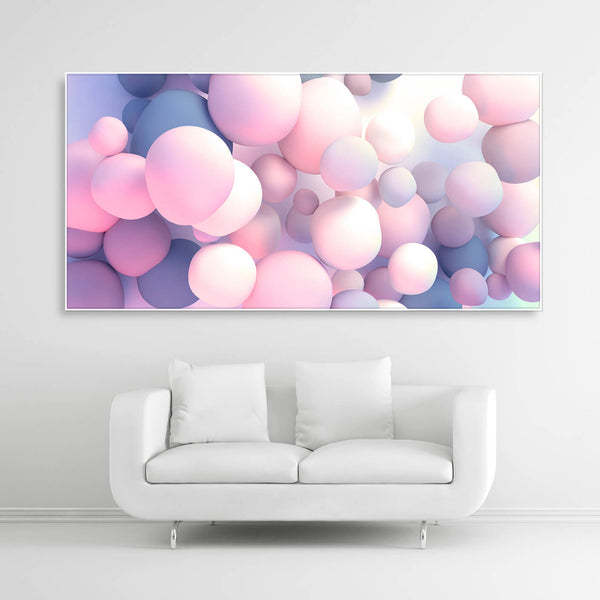 Schallschutzbild mit rosa-blau pastellfarbenden Ballons in unterschiedlicher Größe frei schwebend. Weißer Bilderrahmen im Querformat 2 zu 1 über weißem Sofa.