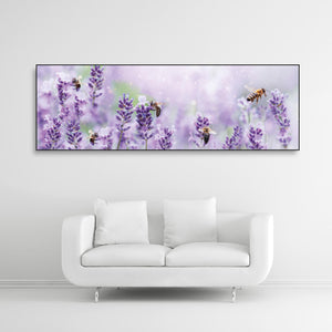 Schallschutzbild mit Macroaufnahme von Lavendelblüten mit Bienen. Schwarzer Rahmen im Querformat über weißem Sofa.