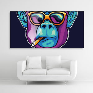 Tysta Akustikbild eines poppigen Affengesichts mit qualmender Zigarre und Sonnenbrille. Schwarzer Bilderrahmen im Querformat 2 zu 1 über weißem Sofa.