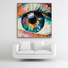 Schallschutzbild mit dick aufgetragener Farbe gemaltes, abstraktes Auge in bunten Farbtönen. Schwarzer Rahmen in Quadrat über weißem Sofa.