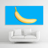 Tysta Akustikbild mit Fotografie einer gelben Banane auf hellblauen Hintergrund. Weißer Rahmen im Querformat 2 zu 1 über weißem Sofa.