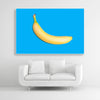 Tysta Akustikbild mit Fotografie einer gelben Banane auf hellblauen Hintergrund. Weißer Rahmen im Querformat 3 zu 2 über weißem Sofa.