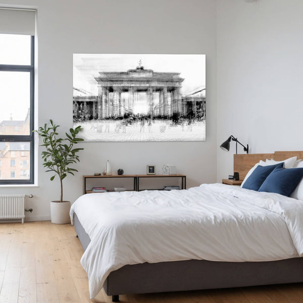 Schwarz-Weiß-Fotodruck des Brandenburger Tors in Berlin, aufgehängt über einem Bett in einem modernen Schlafzimmer. Das Bild zeigt das Tor in verschwommener Mehrfachbelichtung, was den Eindruck von Bewegung und Dynamik erzeugt. Menschen und Fahrzeuge verschwimmen vor dem Tor, während die Architektur selbst klar und deutlich bleibt.