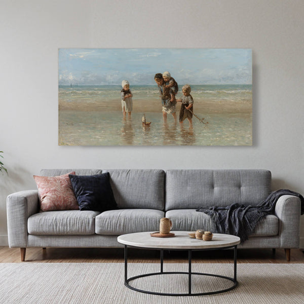 Ein Akustikbild von Jozef Israels' "Kinder am Meer" hängt über einem modernen grauen Sofa in einem minimalistischen Wohnzimmer. Das Gemälde zeigt vier Kinder, die am Strand spielen. Ein Kind trägt ein anderes Huckepack, während die anderen zwei im flachen Wasser spielen und ein Spielzeugboot ziehen. Das Sofa wird von einem runden Couchtisch aus Marmor und dekorativen Kissen ergänzt.