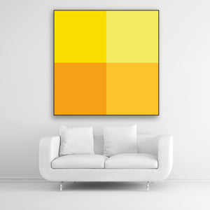 Tysta Akustikbild Colorline Yellow mit vier Vollfarben aus Gelbtönen. Schwarzer Bilderrahmen im Quadrat über weißem Sofa.