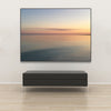 Akustikbild Silent Ocean 2 von Tan Kulali mit abstraktem Meerblick bei Sonnenuntergang. Querformat 4 zu 3 mit schwarzem Rahmen über Sitzbank.