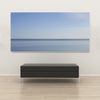 Akustikbild Silent Ocean 4 von Tan Kulali mit abstraktem Meereshorizont in Blautönen. Querformat 2 zu 1 mit weißem Rahmen über Sitzbank.