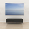 Akustikbild Silent Ocean 4 von Tan Kulali mit abstraktem Meereshorizont in Blautönen. Querformat 3 zu 2 mit weißem Rahmen über Sitzbank.