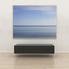 Akustikbild Silent Ocean 4 von Tan Kulali mit abstraktem Meereshorizont in Blautönen. Querformat 4 zu 3 mit weißem Rahmen über Sitzbank.
