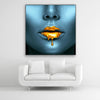 Schallschutzbild Golden Lips mit blauem, weiblichen Gesicht mit goldener, flüssigen Farbe auf den Lippen. Schwarzer Rahmen im Quadrat.