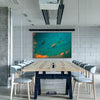 Konferenzraum im Fabrikstil mit langem Tisch, Stühlen und Schallschutzbild Atolll von JR Korpa. Farbspiel von Blau- und Orangetönen mit schwarzem Rahmen.